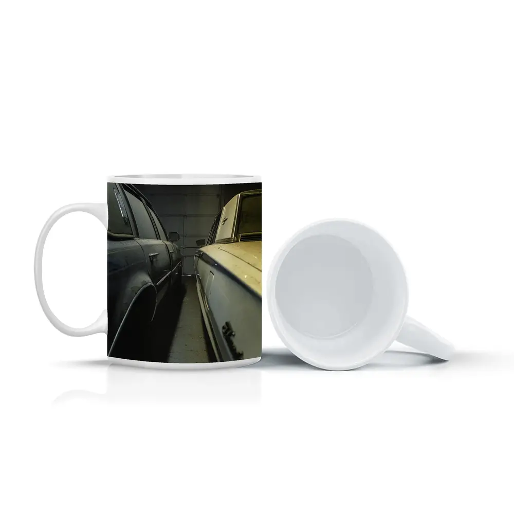 Two Classic Cars Parked Inside Dark Garage – Mugs