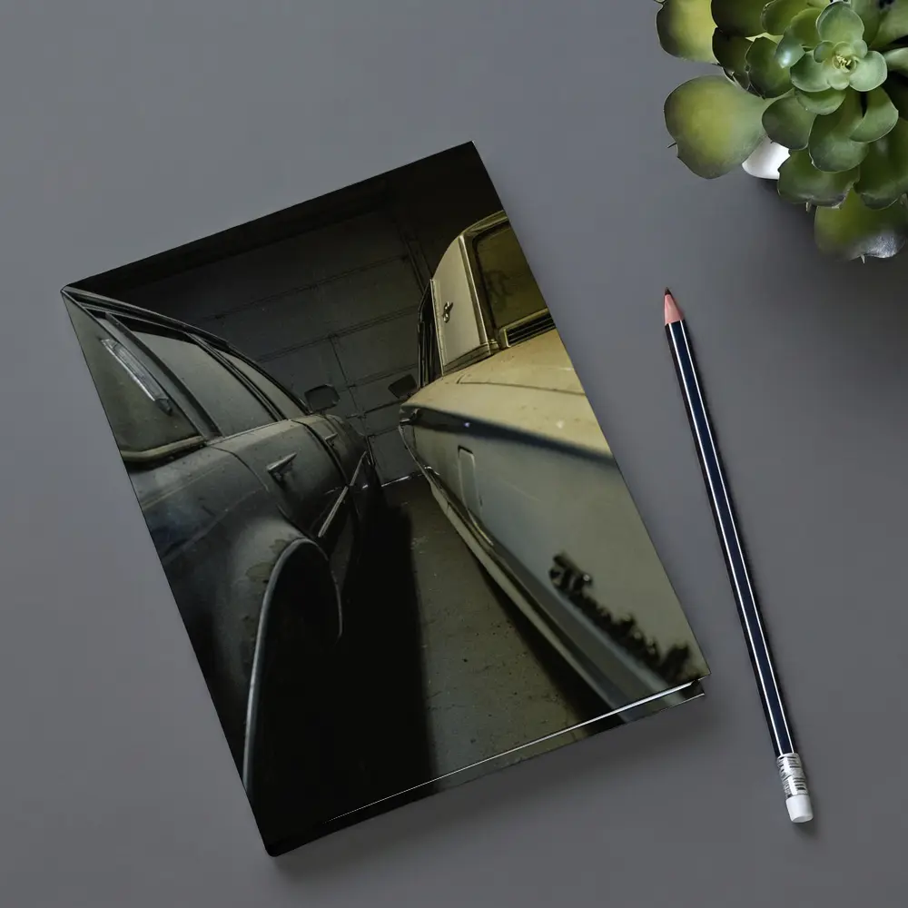 Two Classic Cars Parked Inside Dark Garage – Notebooks