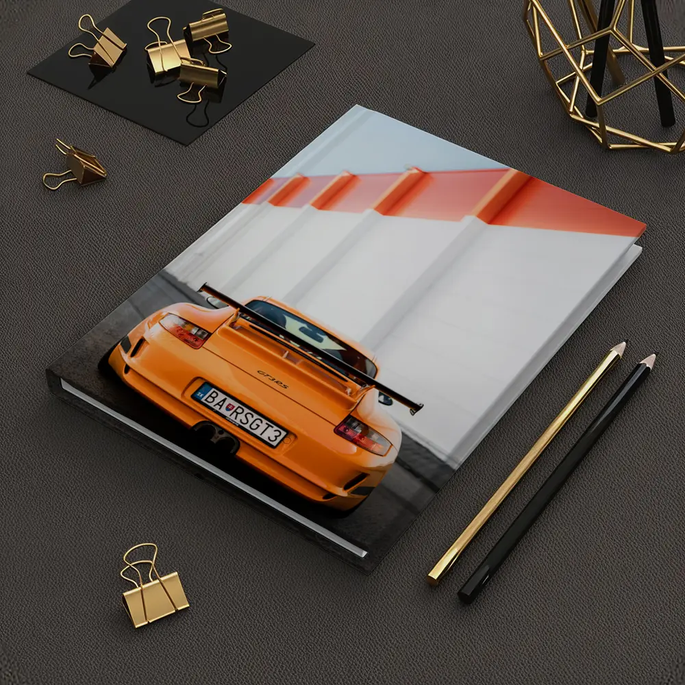 Porsche GT3 RS Orange Against Industrial Wall – Notebooks