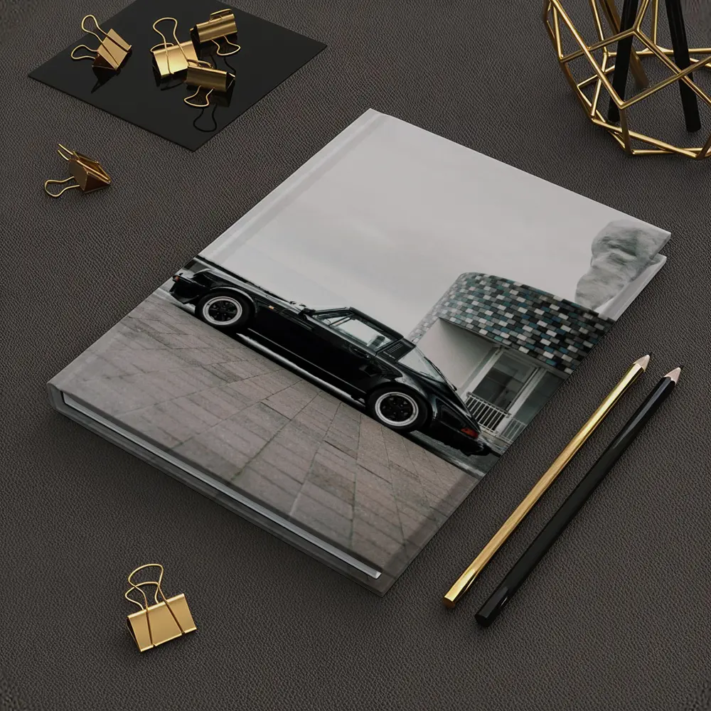 Black Porsche 911 Parked by Coastal Building – Notebooks