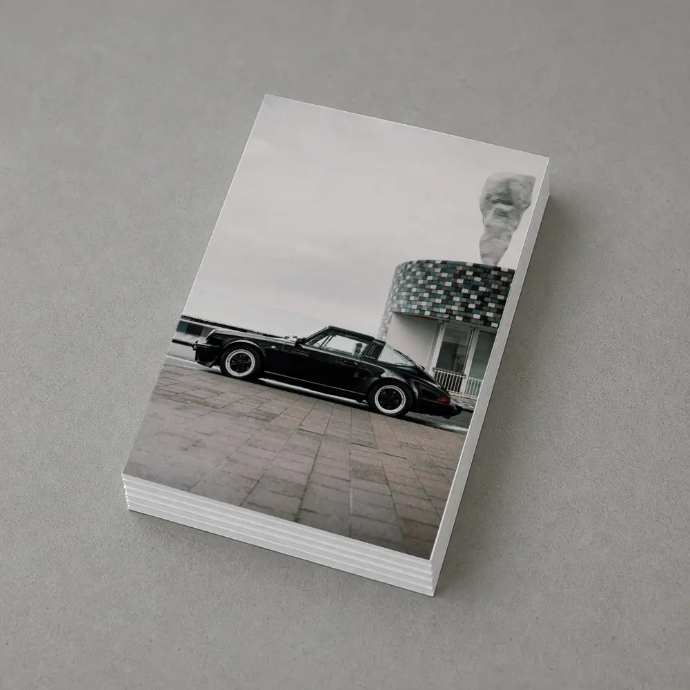 Black Porsche 911 Parked by Coastal Building – Postcards