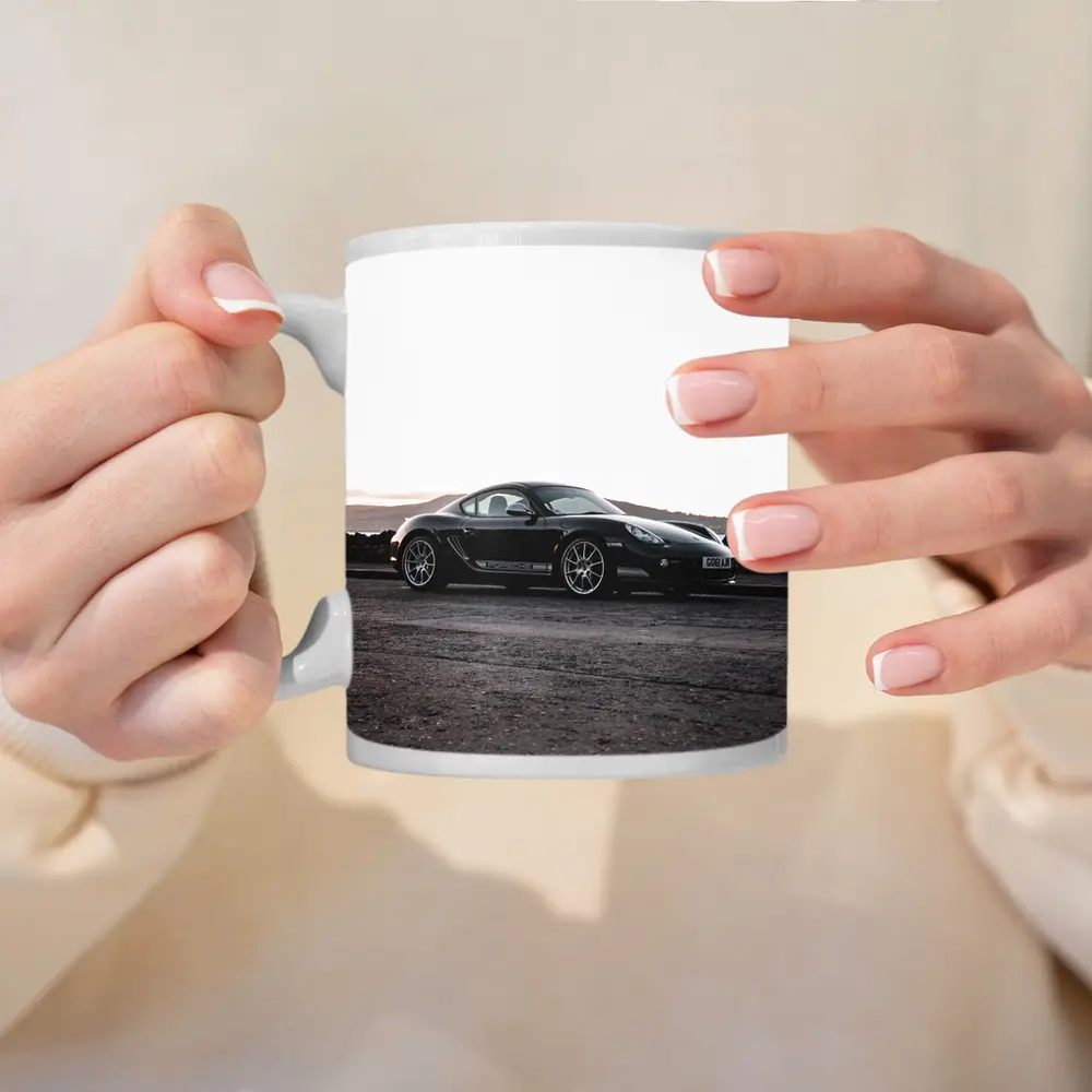 Black Porsche Cayman Parked on Rugged Terrain – Mugs