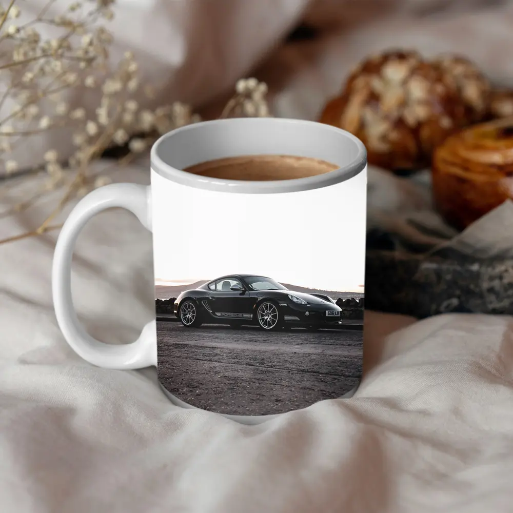 Black Porsche Cayman Parked on Rugged Terrain – Mugs