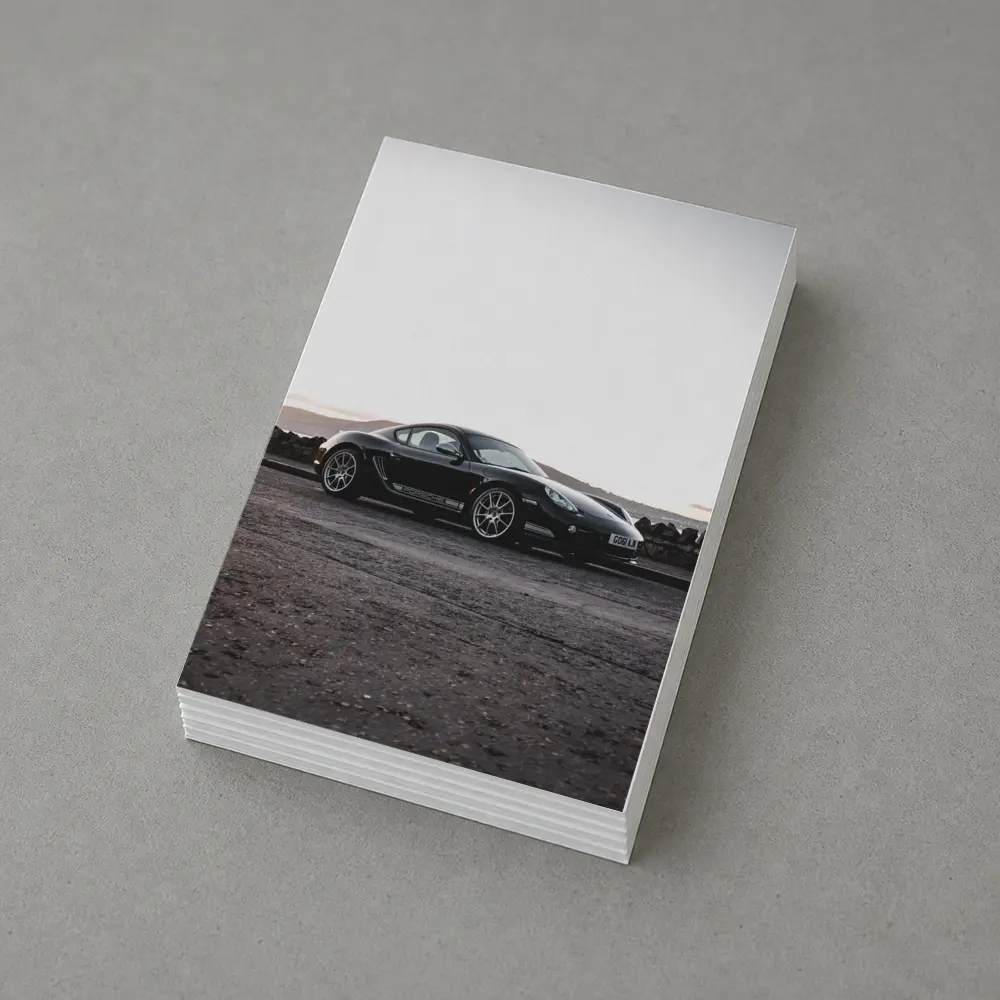Black Porsche Cayman Parked on Rugged Terrain – Postcards
