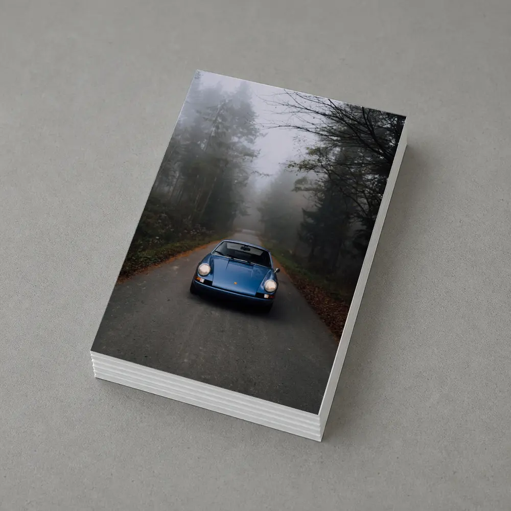 Blue Porsche 911 on Foggy Forest Road – Postcards