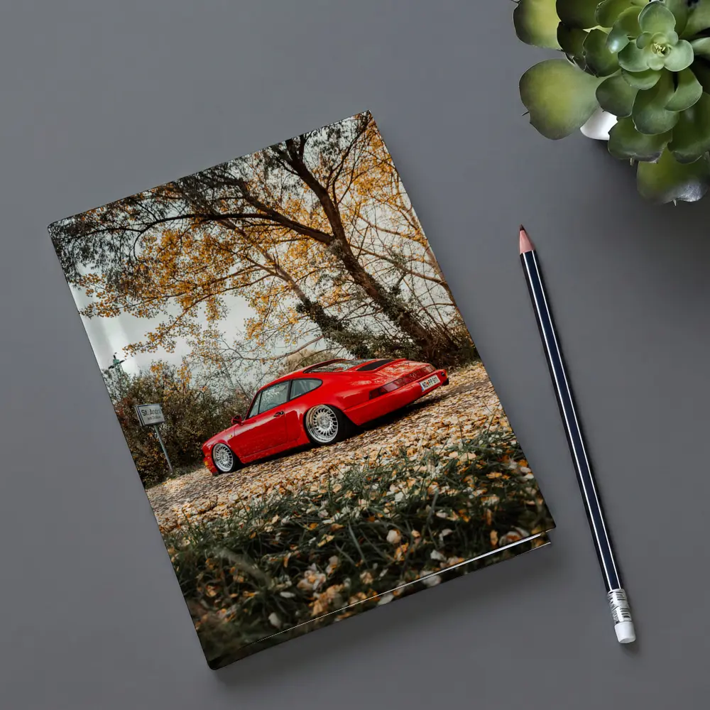 Red Porsche 911 Parked Among Autumn Leaves – Notebooks