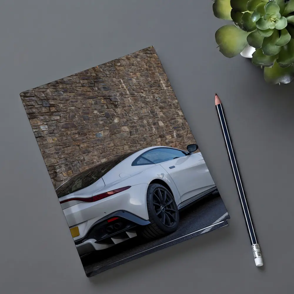 Aston Martin Vantage White Against Stone Wall – Notebooks