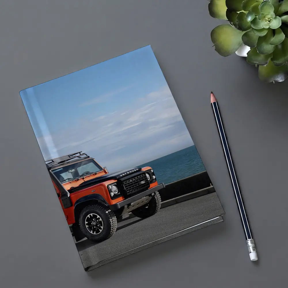 Land Rover Defender Orange Coastal Road Scene – Notebooks