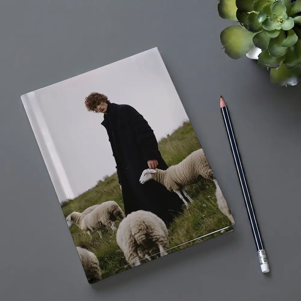 Young Man Black Coat Sheep Green Field – Notebooks