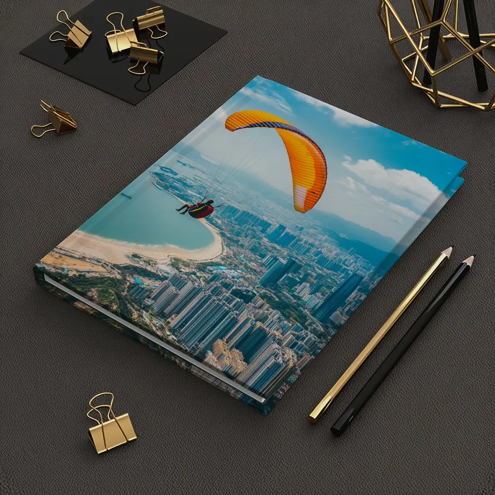 Paraglider Soaring Over Coastal City Skyline – Notebooks