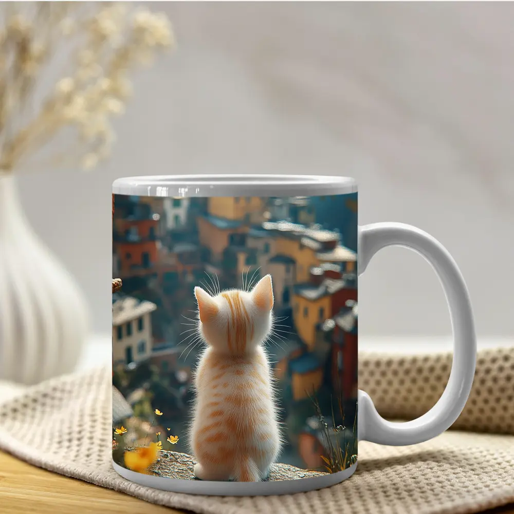 Orange Kitten Overlooking Colorful Hillside Village – Mugs