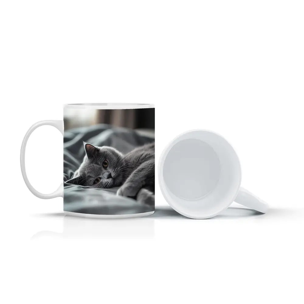 British Shorthair Cat Resting On Gray Bedding – Mugs