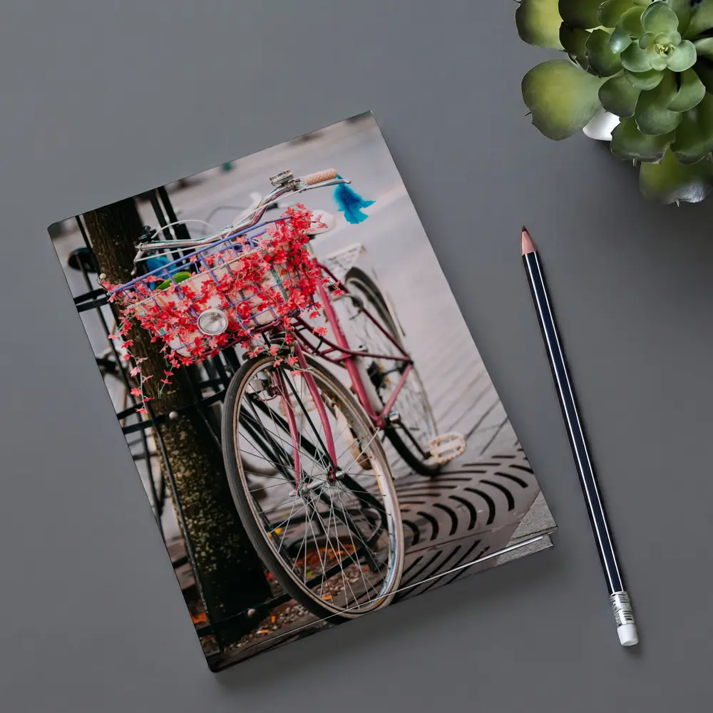 Pink Bicycle With Flowers On City Street – Notebooks