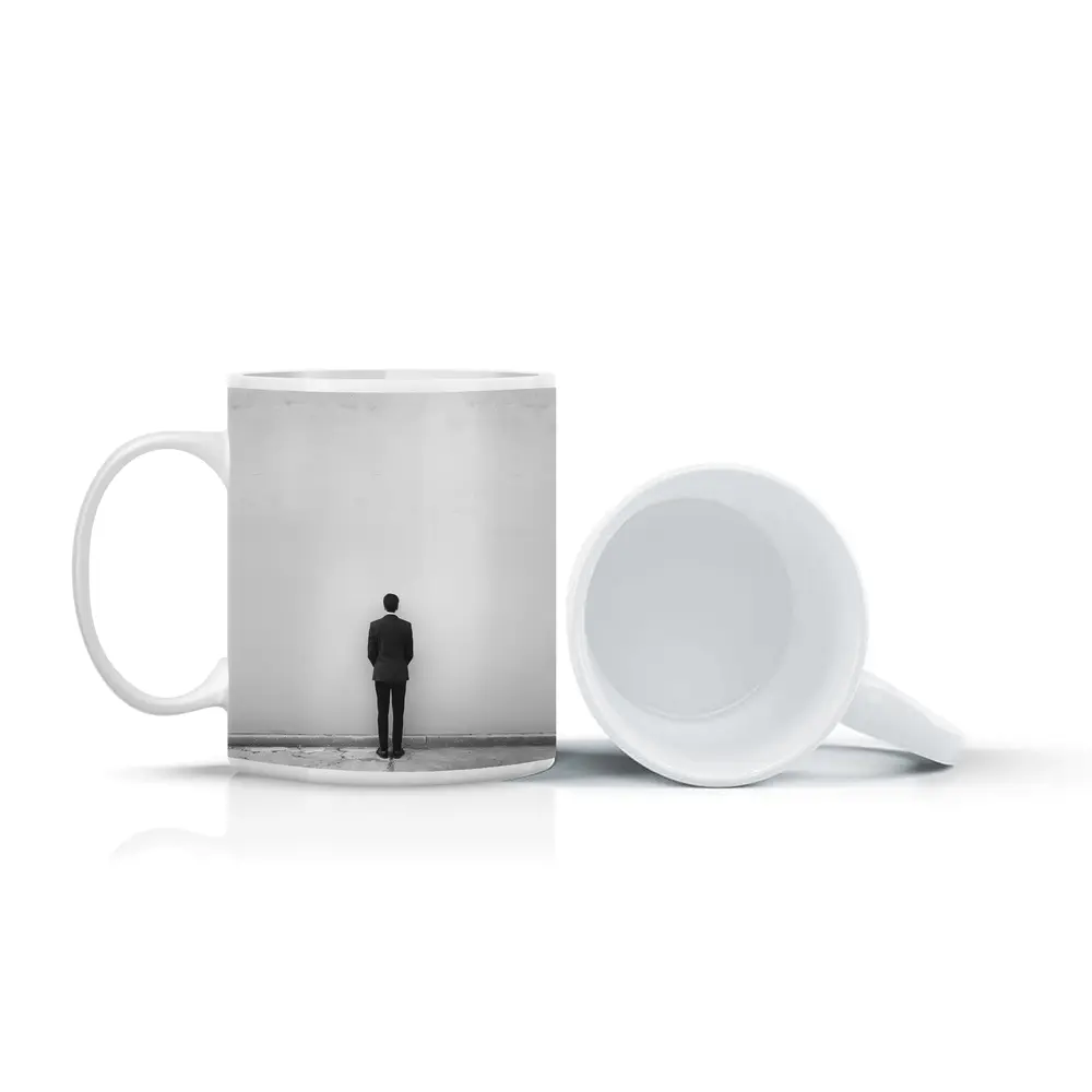 Man in Suit Standing Against White Wall – Mugs