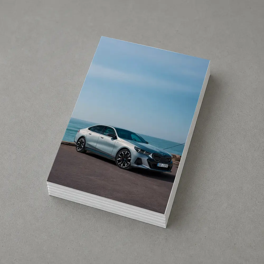 BMW i5 Sedan Parked by the Ocean – Postcards