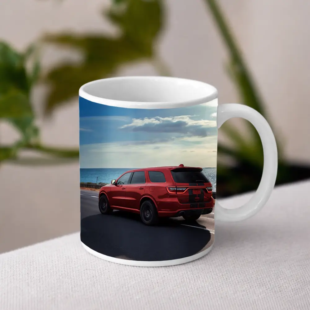 Red Dodge Durango Driving Along Coastal Road – Mugs