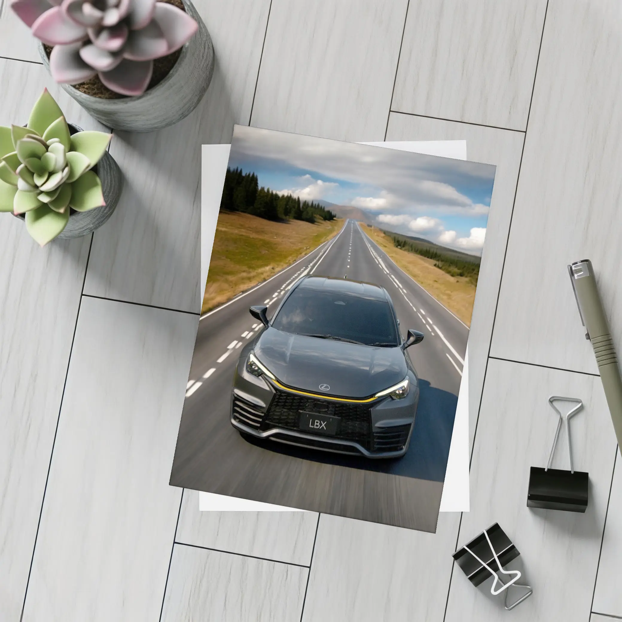 Lexus LBX Driving Open Road Dramatic Sky – Postcards