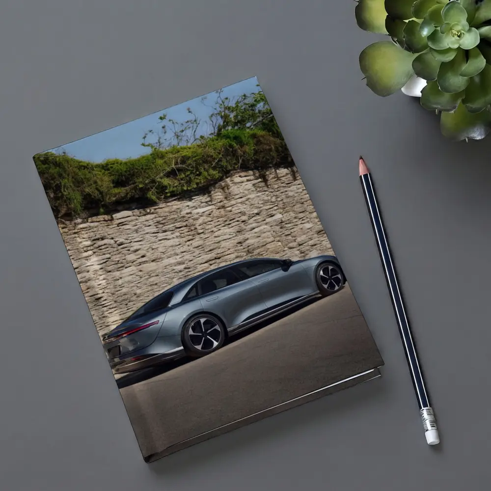 Lucid Air Sedan Parked By Stone Wall – Notebooks