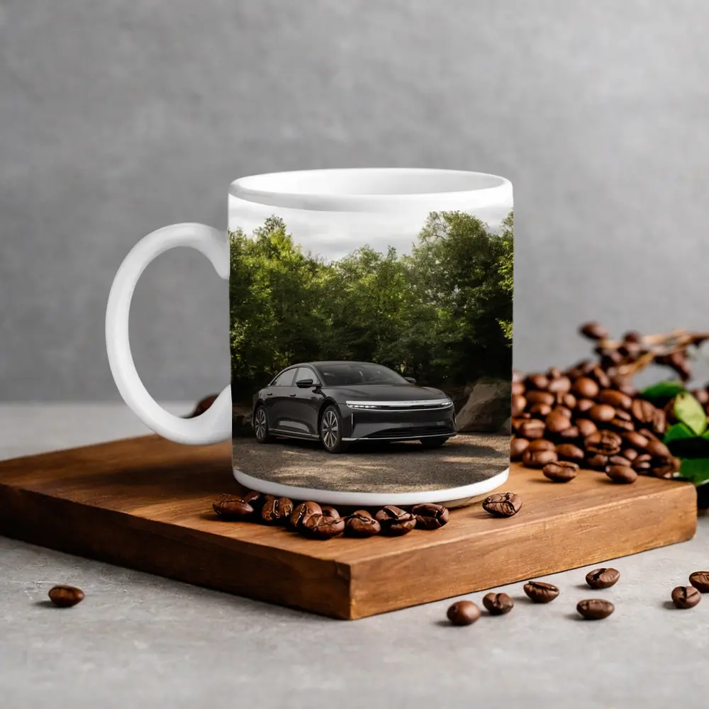 Lucid Air Dark Sedan Parked Among Trees – Mugs