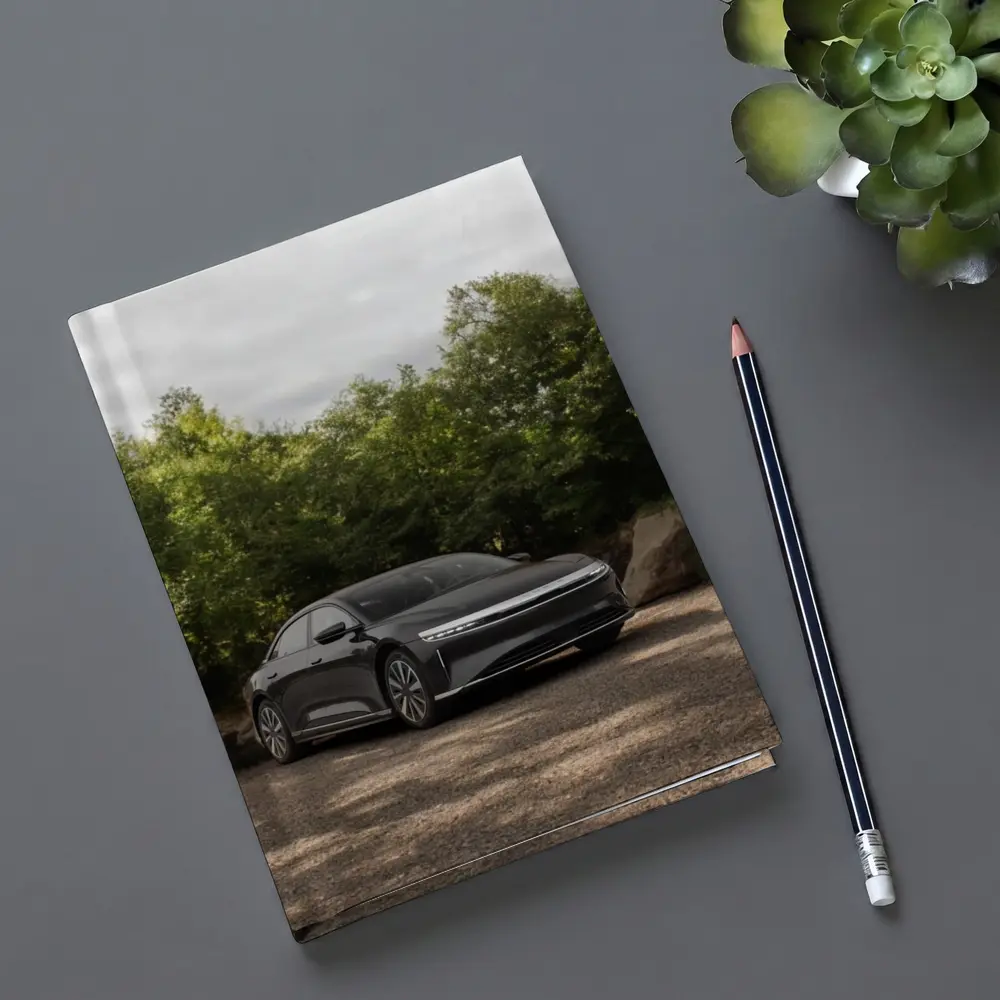Lucid Air Dark Sedan Parked Among Trees – Notebooks