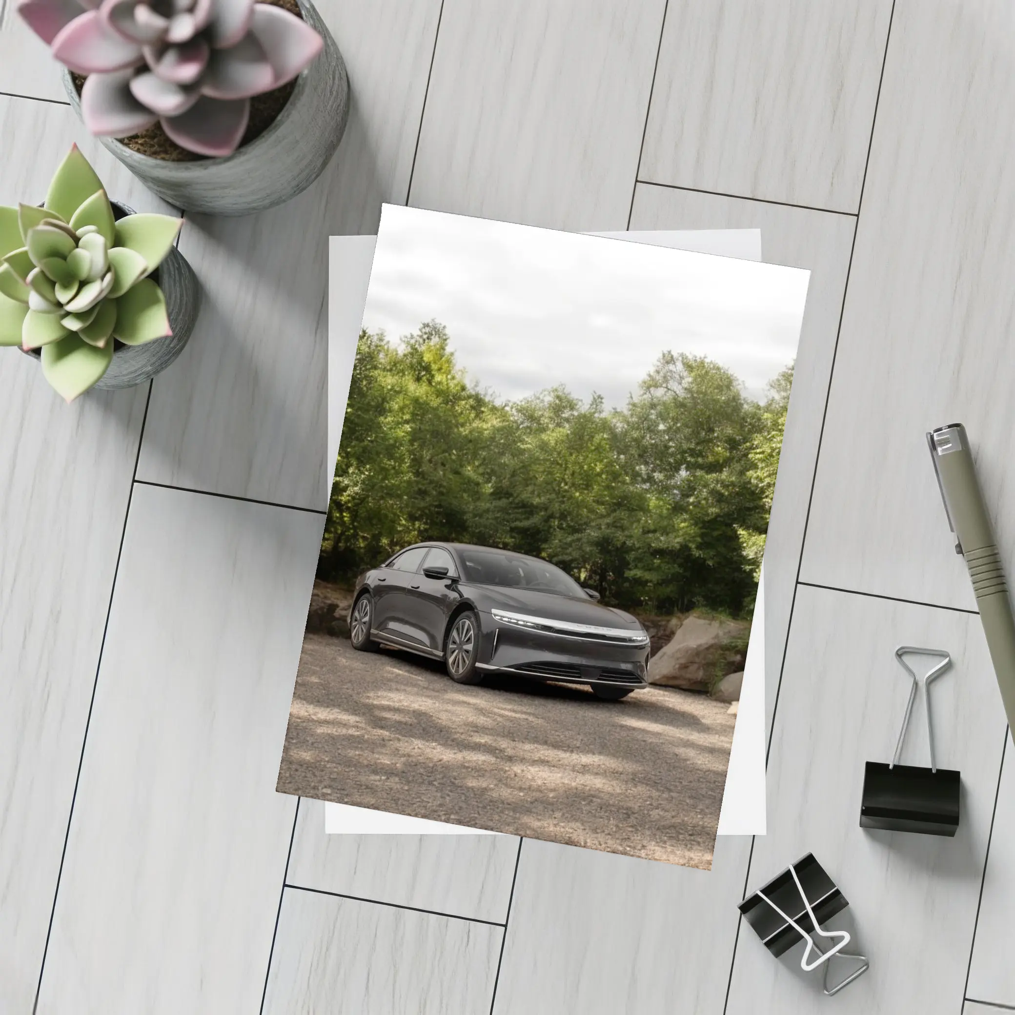Lucid Air Dark Sedan Parked Among Trees – Postcards