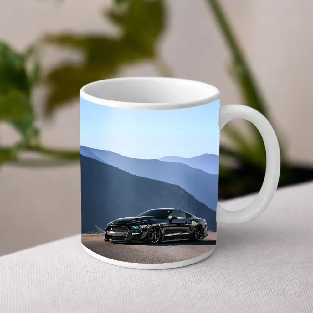 Black Ford Mustang Parked Against Mountain Backdrop – Mugs
