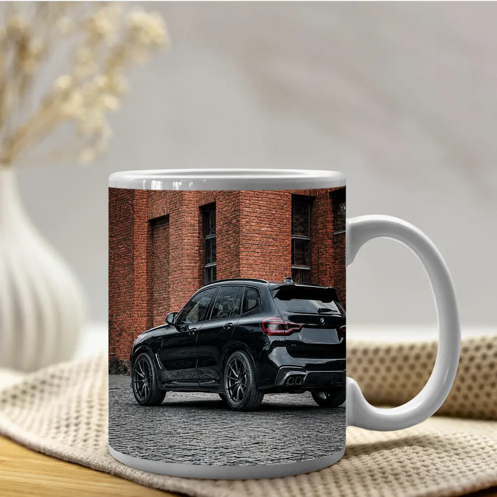 Black BMW X5M Parked Near Brick Building – Mugs