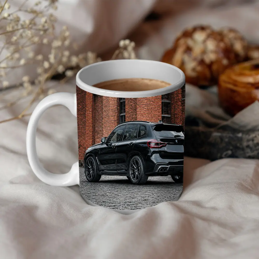 Black BMW X5M Parked Near Brick Building – Mugs