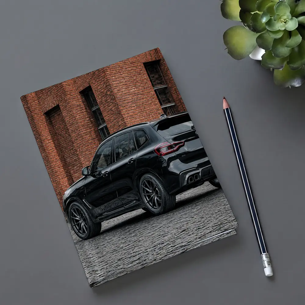 Black BMW X5M Parked Near Brick Building – Notebooks