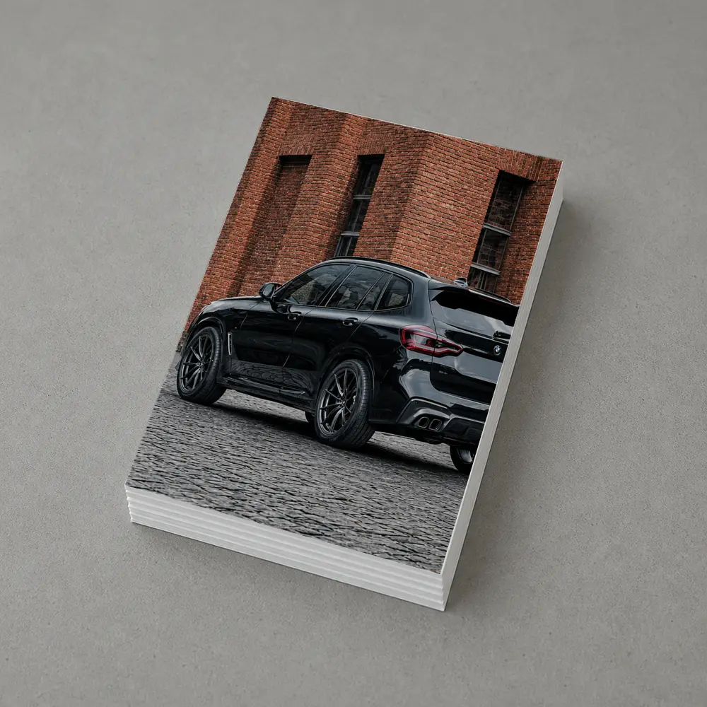 Black BMW X5M Parked Near Brick Building – Postcards