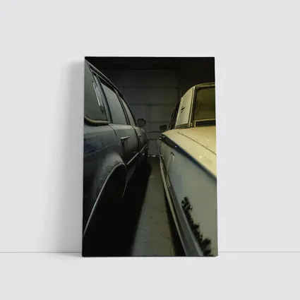 Two Classic Cars Parked Inside Dark Garage
