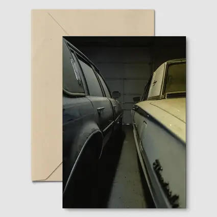 Two Classic Cars Parked Inside Dark Garage