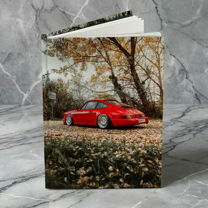 Red Porsche 911 Parked Among Autumn Leaves
