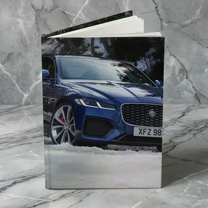 Jaguar XF Blue Sedan Driving Through Snow