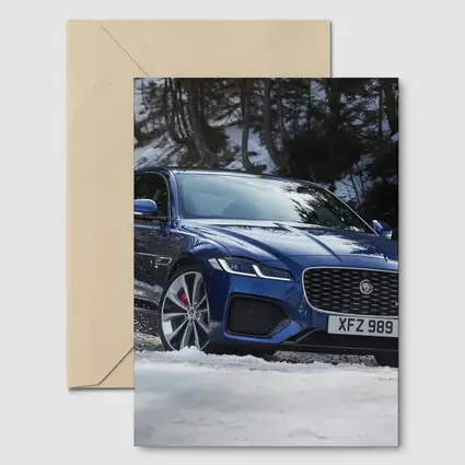 Jaguar XF Blue Sedan Driving Through Snow