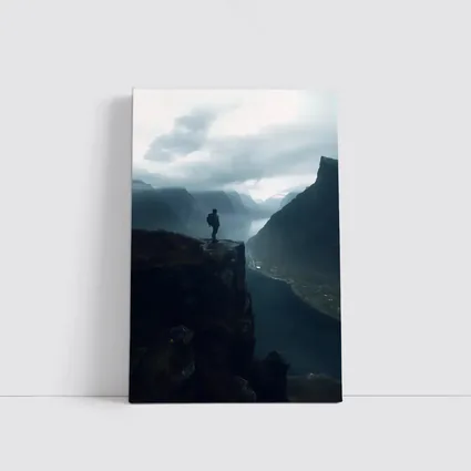 Hiker Standing On Cliff Above Misty Fjord