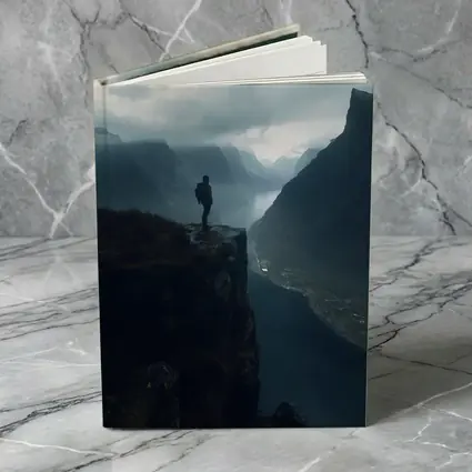 Hiker Standing On Cliff Above Misty Fjord