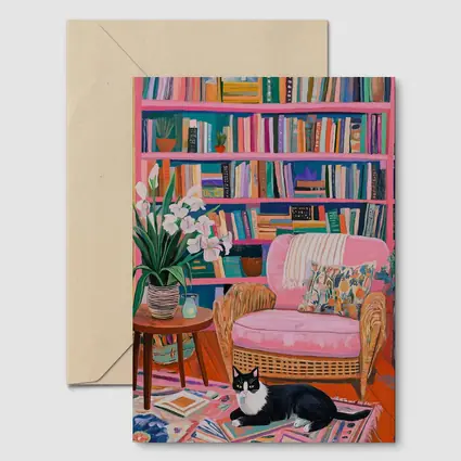 Tuxedo Cat Resting In Colorful Bookshelf Room