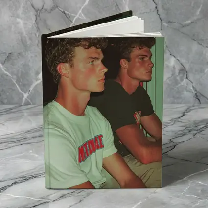 Two Young Men Sitting Together Indoors