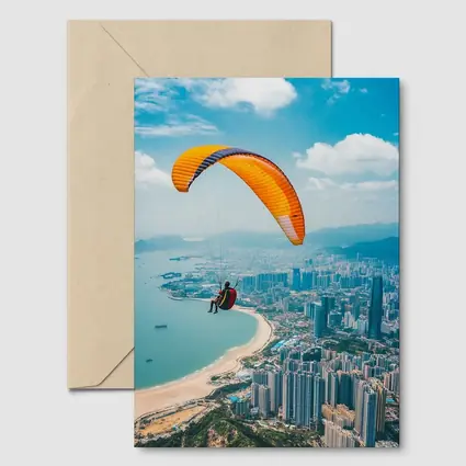 Paraglider Soaring Over Coastal City Skyline