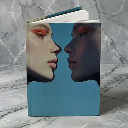 Two Women Facing Orange Eye Makeup Blue
