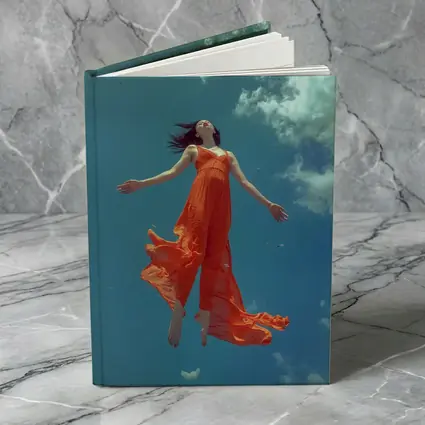 Woman Floating in Blue Sky Orange Dress