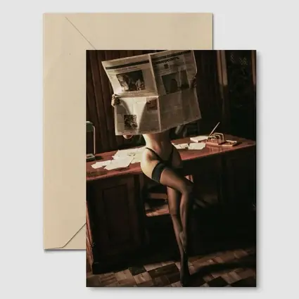 Sexy Woman Reading Newspaper at Office Desk