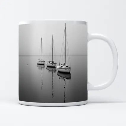 Three Sailboats Reflecting on Foggy Water
