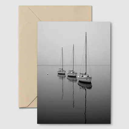 Three Sailboats Reflecting on Foggy Water