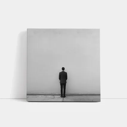 Man in Suit Standing Against White Wall