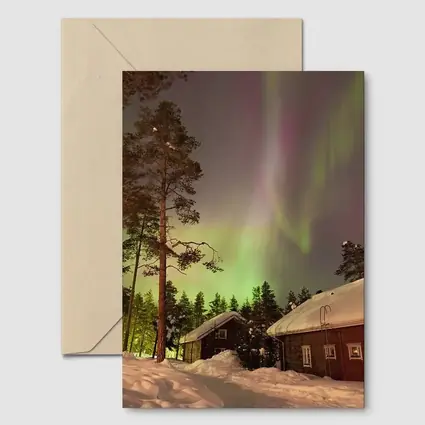 Northern Lights Over Snowy Winter Cabins