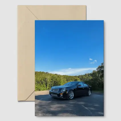 Black Cadillac CTS Parked Against Blue Sky