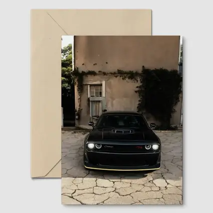 Black Dodge Challenger Parked Before Old House
