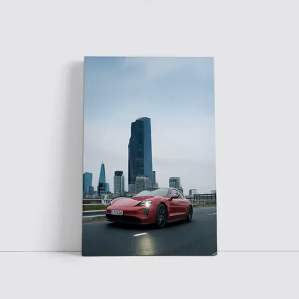 Red Porsche Taycan Driving Through City Skyline